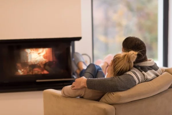 Kuscheln zu zweit Couch vor Kaminfeuer gegen Winterdepression wirken