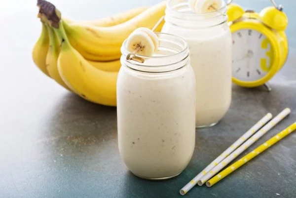 Bananen Smoothies mit Milch im Glas für gesundes Frühstück