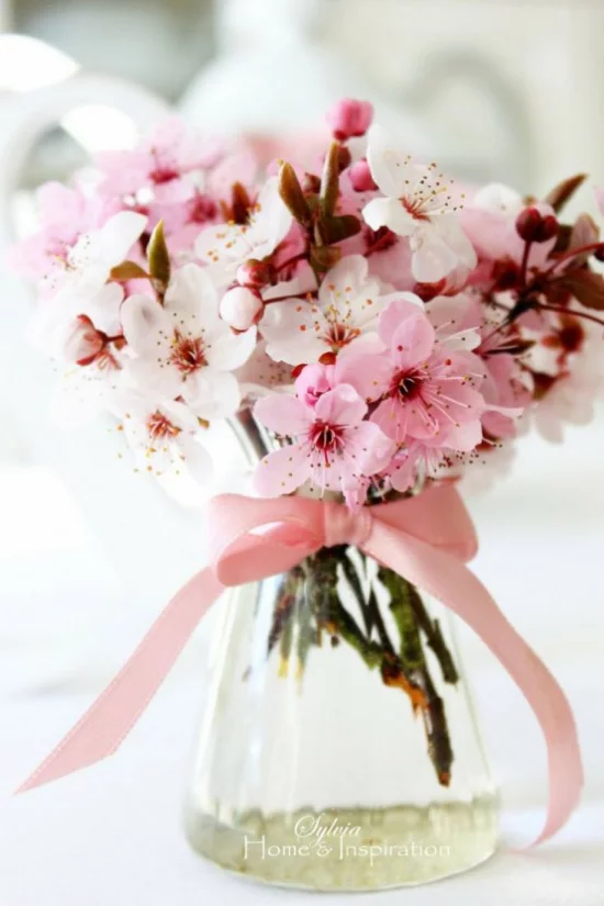 Frühlingsdeko mit Kirschblüten rosa Blüten im Glas rosa Schleife