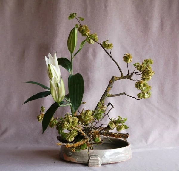 weiße lilie zweige moos ikebana