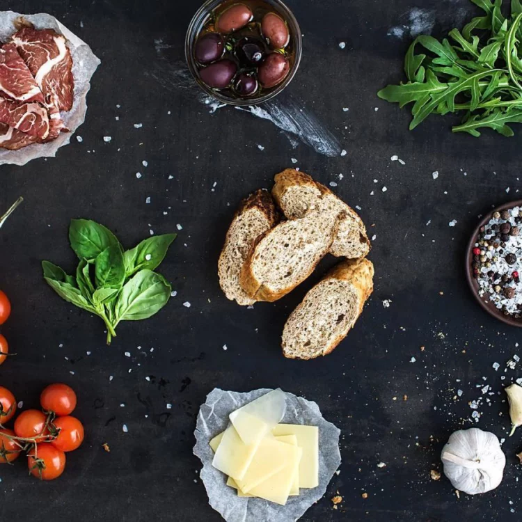 Gesundes und ausgewogenes Essen in Zeiten der Corona-Krise Brot Käse Oliven Fleisch Tomaten Basilikumblätter