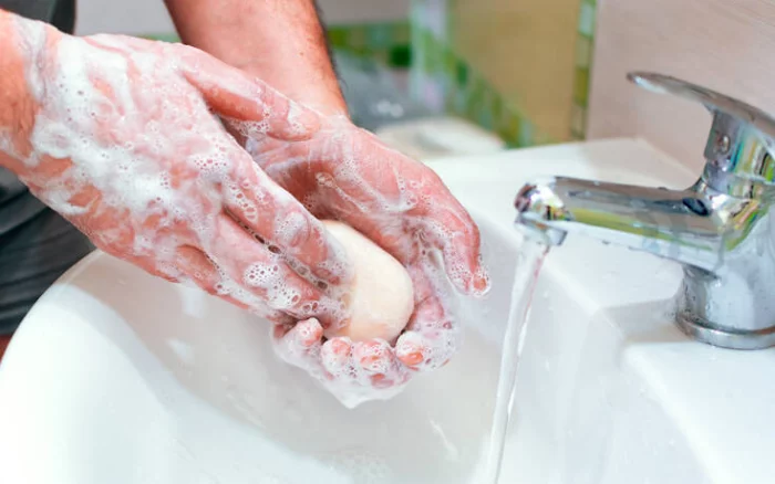 Richtiges Händewaschen mit Seife unter fließendem Wasser die COVID-19-Pandemie bekämpfen