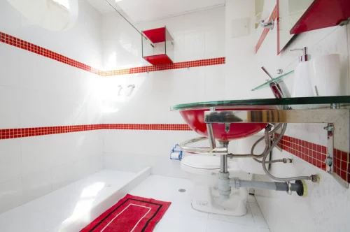 Badezimmer in Rot super modernes Baddesign Weiß dominiert Akzente in Rot kleiner Teppich Fliesen