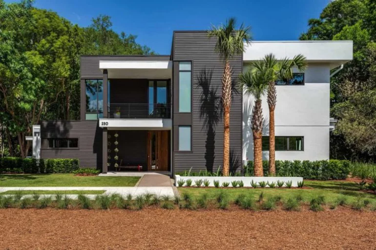 Einfamilienhaus in Florida mit offenem Wohnkonzept Aussicht von der Straße viel Grün ringsum elegante Hausfassade