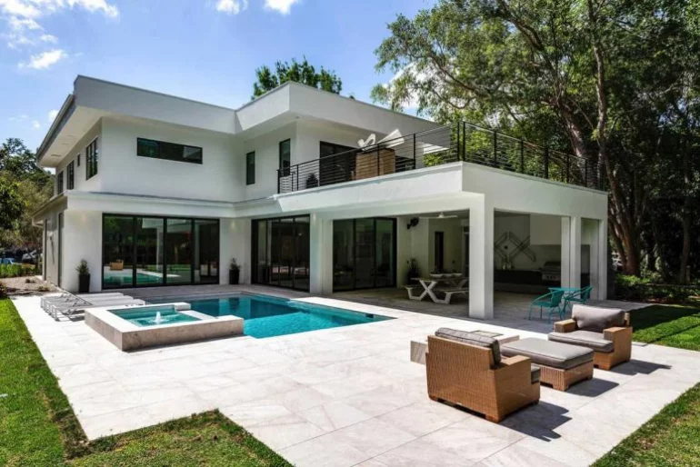 Einfamilienhaus in Florida mit offenem Wohnkonzept Outdoor-Bereich auf der Hinterseite des Hauses Gartenpool Whirlpool Sitzbereich im Freien