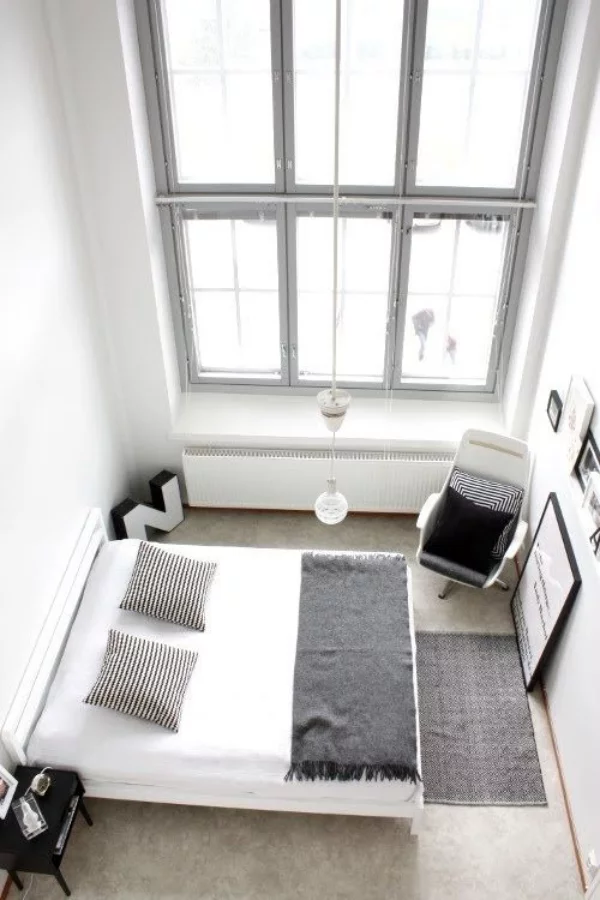 Schlafzimmer minimalistisch einrichten großes Fenster Schlafbett Sessel in der Ecke weniger ist mehr
