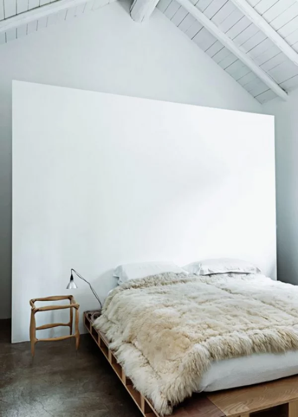 Schlafzimmer minimalistisch einrichten rustikale Elemente im Raumdesign Wurfdecke aus Wolle Balken an der Decke