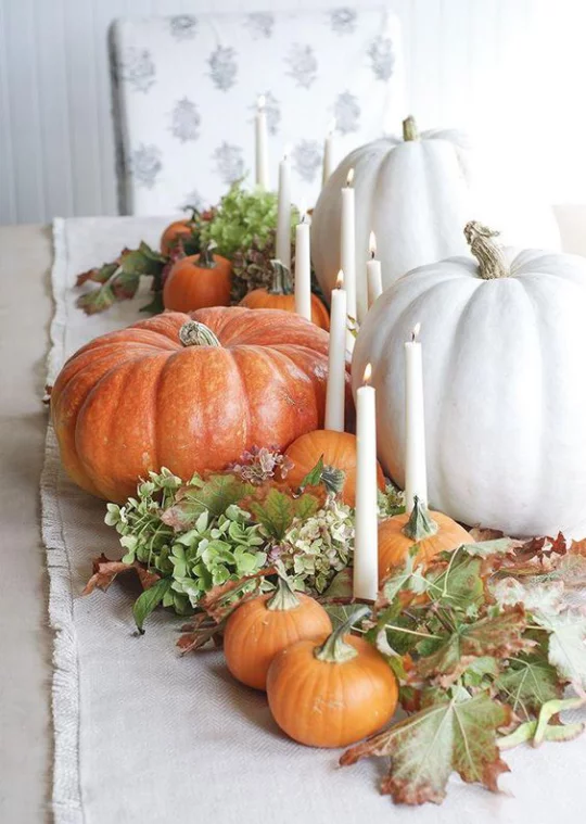 Deko Ideen mit Herbstblättern Tisch gedeckt und dekoriert mit weißen und orangenen Kürbissen