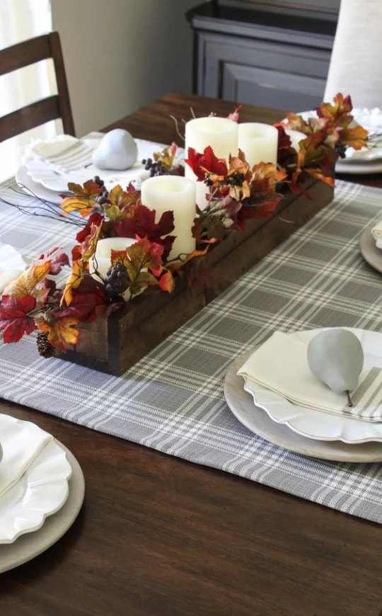 Deko Ideen mit Herbstblättern Tischdeko Holzkasten mit Blättern weiße Kerzen in der Tischmitte