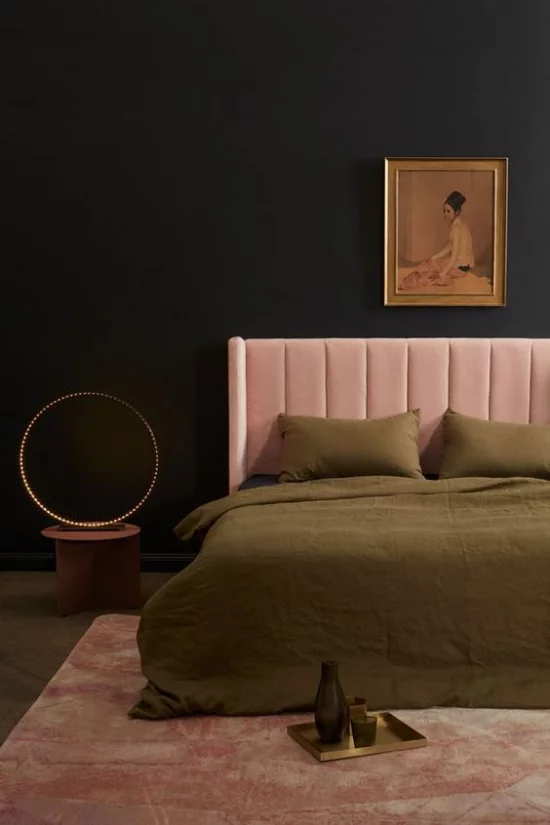 Schlafzimmer Ideen in Schwarz und Rosa rosafarbene Bettpolsterung dunkelgrüne Tagesdecke Kontrast schwarze Wand Wandbild Extravaganz