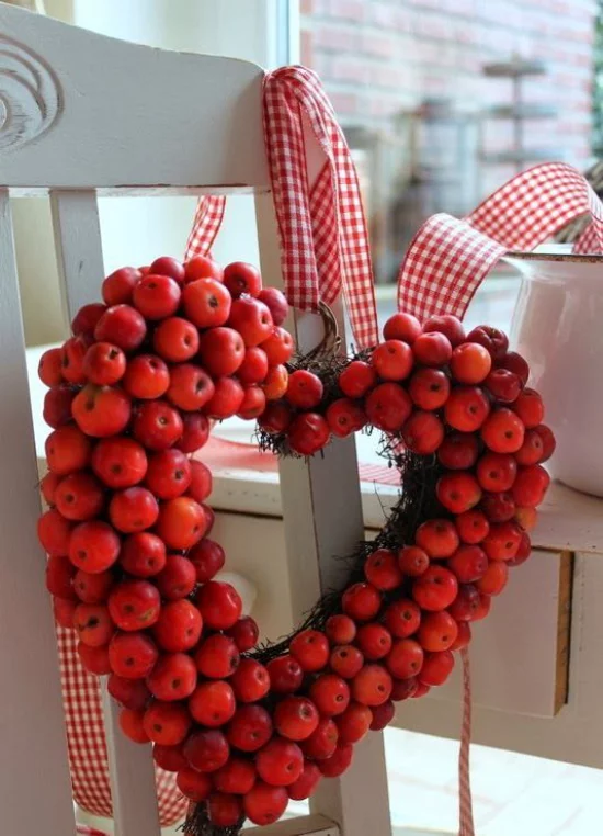 Türkranz mit Äpfeln basteln Kranz in Herzform nur rote Äpfel am Stuhl gehängt weiß-rot karierte Schleife