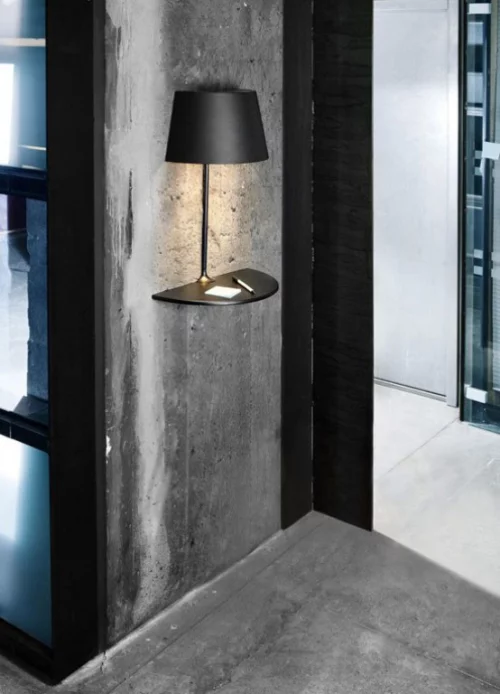 Extravagante Wandleuchten schwarze Wandlampe aus Metall grobe graue Betonwand im Industrial Style im Flur