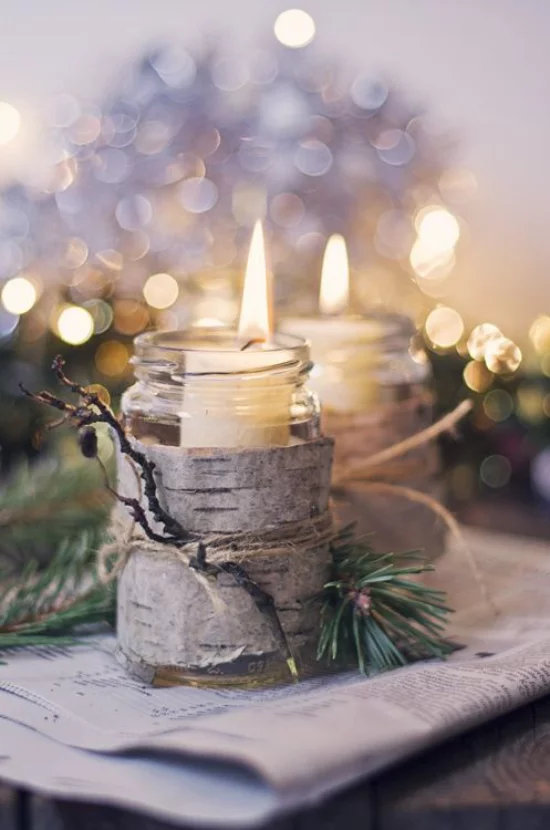 Weihnachsdeko 3 Must-Haves brennende Kerze mit Birkenrinde umwickelt glänzende Lichter im Hintergrund
