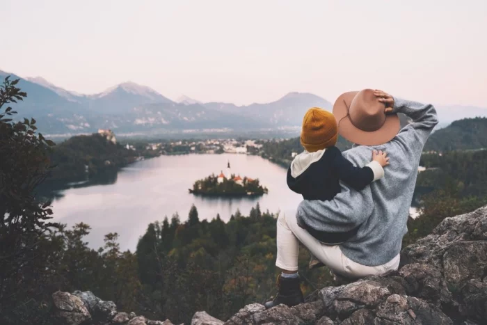 gesund und glücklich im Winter bleiben junge Frau Kleinkind Kurzreise romantischer Panoramablick über einen See kleine Insel altes Schloss