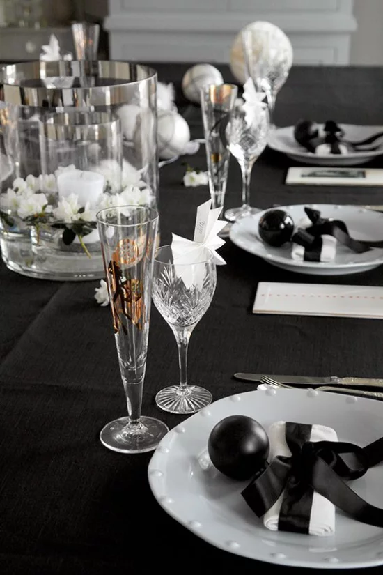 Silvester feiern zu Hause Schwarz bevorzugte Farbe Tischdecke Dekoration weißes Porzellan Kristallgläser