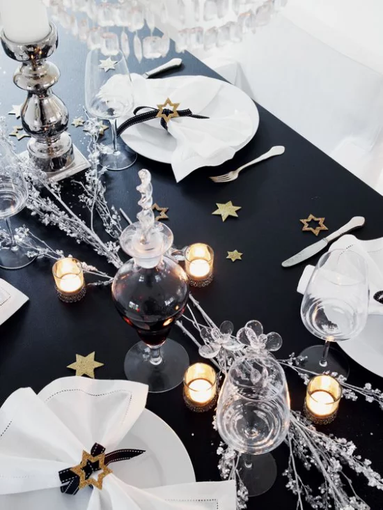 Silvester feiern zu Hause festlich gedeckter Tisch schwarze Tischdecke weißes Service weiße Servietten schöner Kontrast