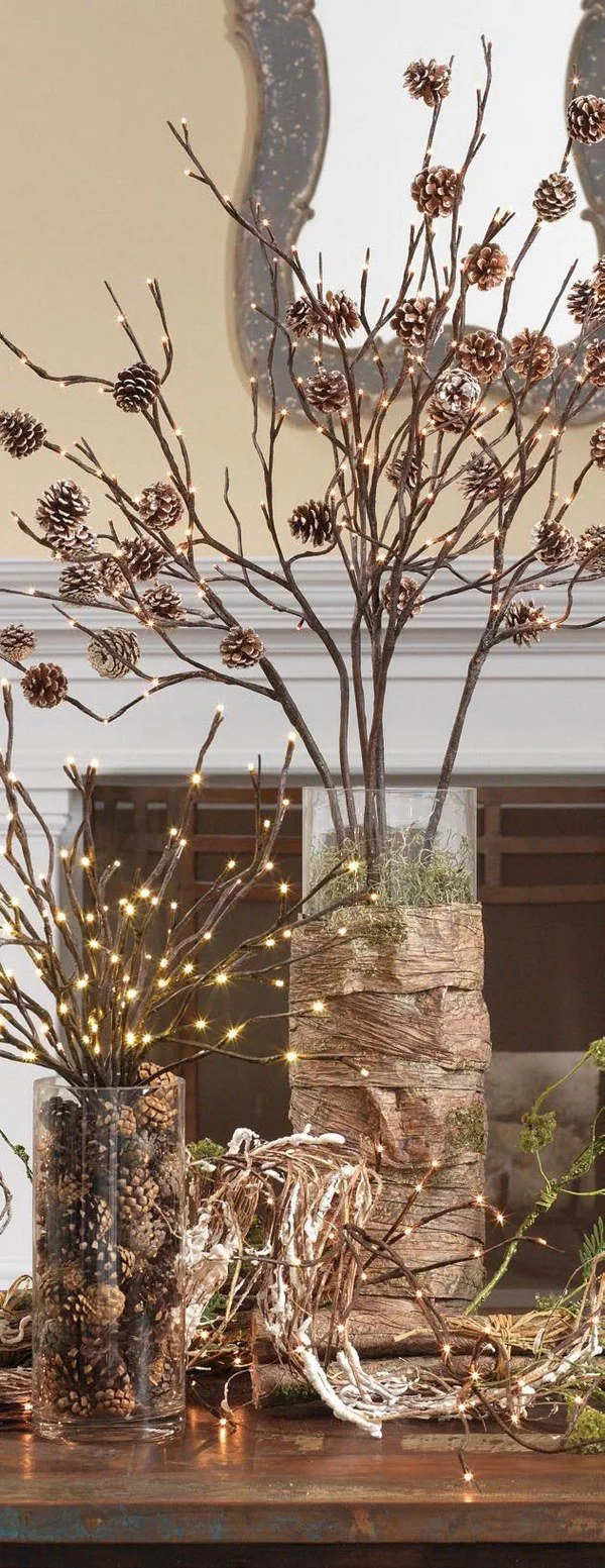 Tannenzapfen Winterdeko im Glasgefäß mit Lichtern an Zweigen befestigt in einer Vase arrangiert