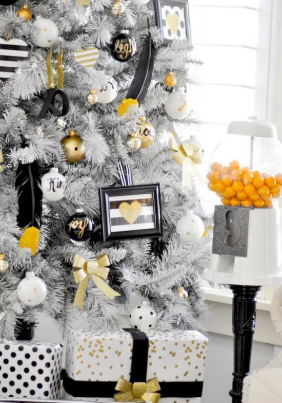 Weihnachtsdeko in Gold und Schwarz weißer Tannenbaum verpackte Geschenke darunter einzelne Akzente in Gold und Schwarz