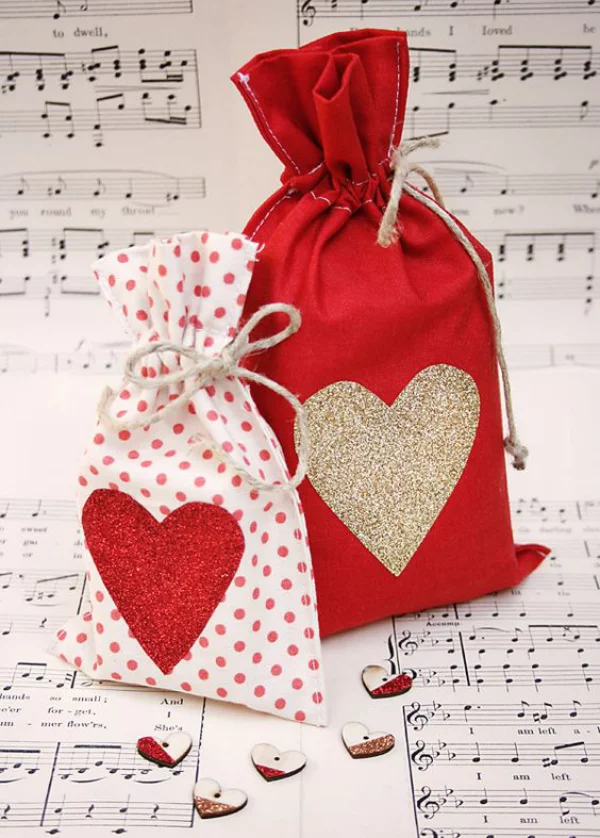 DIY Geschenke zum Valentinstag zwei Geschenktüten aus rotem Stoff mit Herzen dekoriert