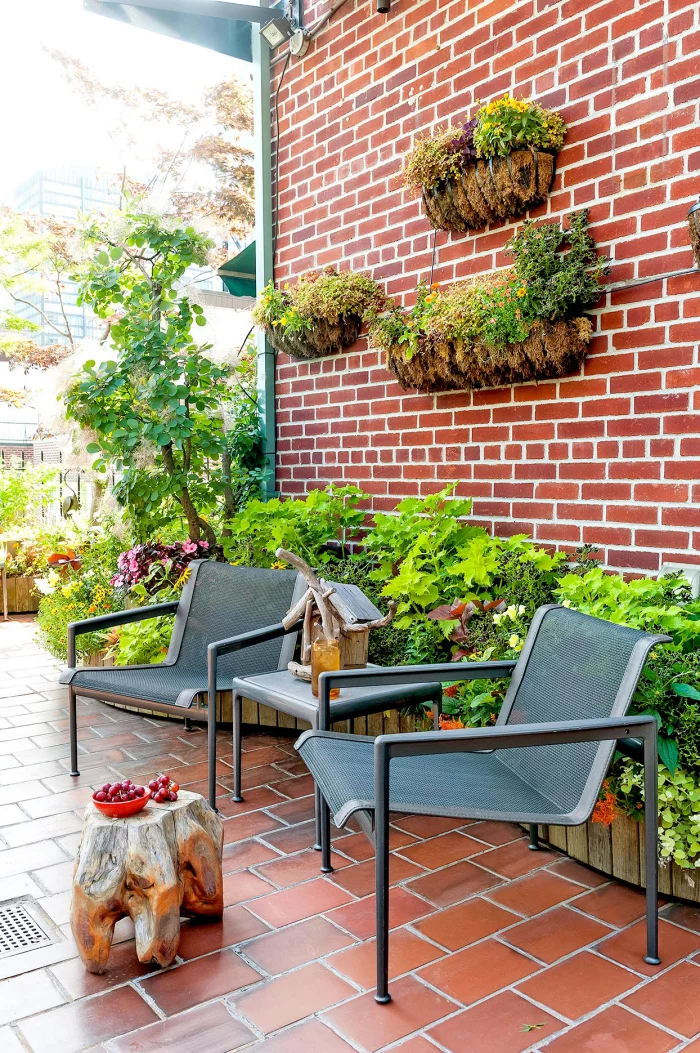 Kleinen Hinterhof einfallsreich gestaltet Sitzecke für zwei Metallstühle Ziegelwand die Zeit im Freien genießen