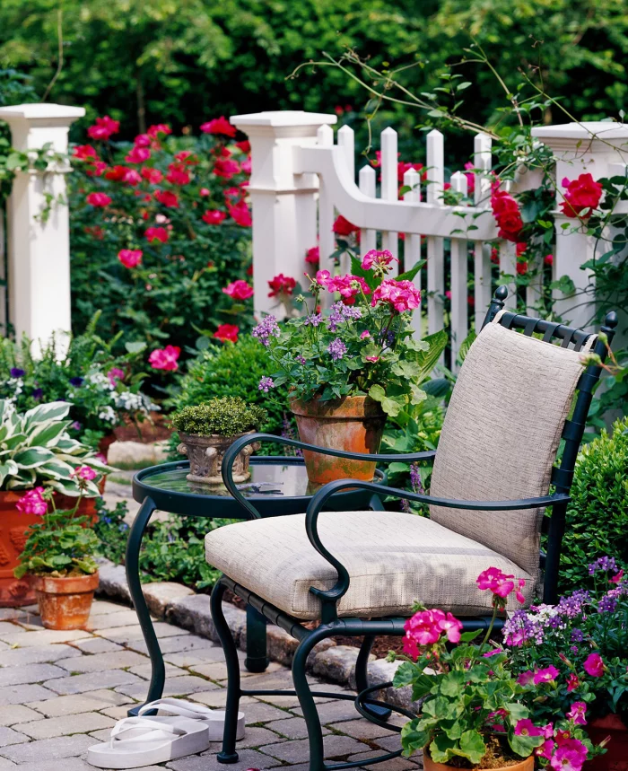 kleinen Garten gestalten Sitzecke halbhoher Zaun viele Gartenpflanzen Topfblumen die Privatsphäre schützen