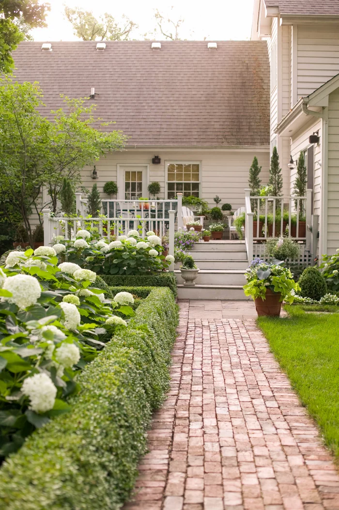 kleinen Garten gestalten Symmetrie weiße Hortensien umrahmen den Pfad zum Haus