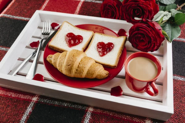 romantisches Frühstück zu zweit Tablett Kaffee mit Milch Croissants rote Rosen Toast mit Marmelade
