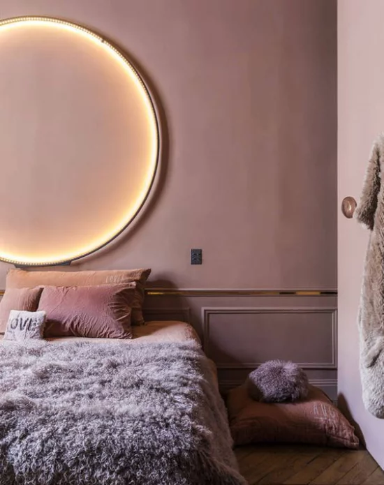 Mauve Farbe dominiert im gemütlichen Schlafzimmer Wandfarbe malvenfarbenes Bettzeug Felldecke