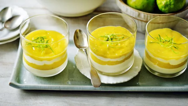 Melonen Desserts in Gläsern in Schichten gestalten gelb und weiß mit grünen Blättern garnieren