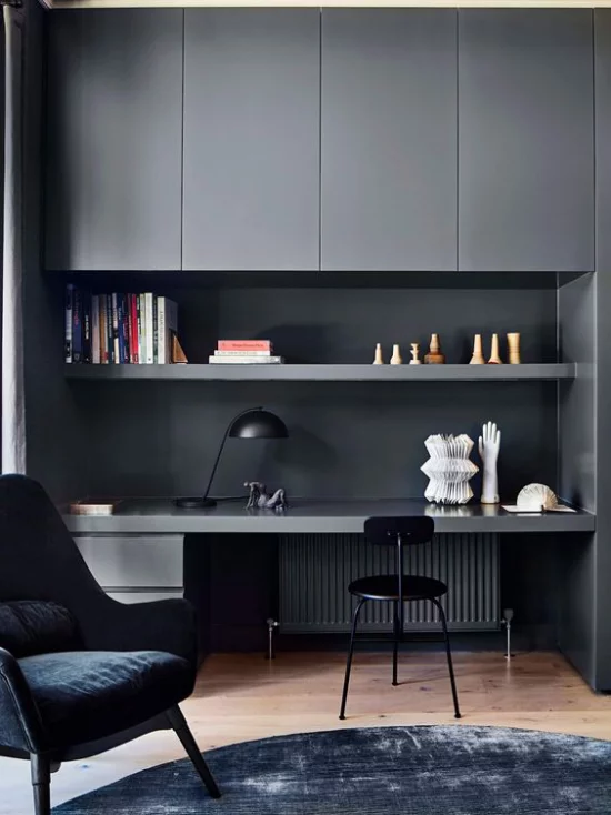 zeitgenössisches Home Office grau dominiert etwas düster wirkt Schreibtisch Oberschränke Stauoptionen dunkler Ledersessel schwarzer Stuhl Teppich