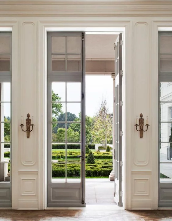 französische Fenstertüren elegantes Raumdesign im klassischen Stil Kerzenständer beiderseits Übergang zum Garten sehr gut gestaltet und gepflegt