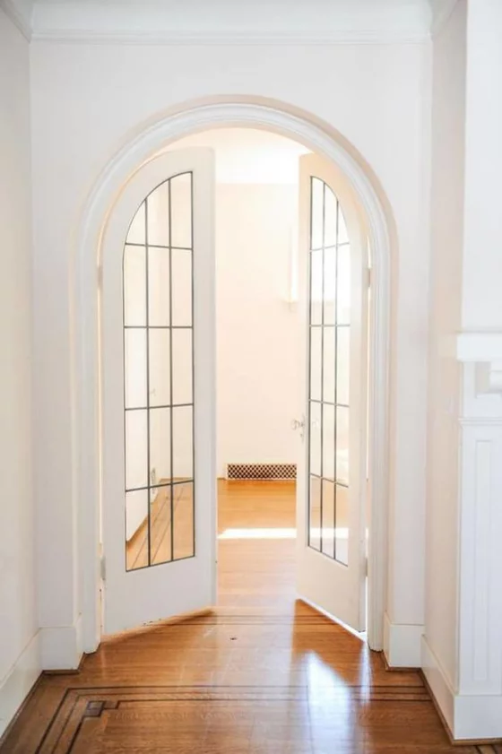 französische Fenstertüren gewölbte Tür weißer Rahmen Parkettboden