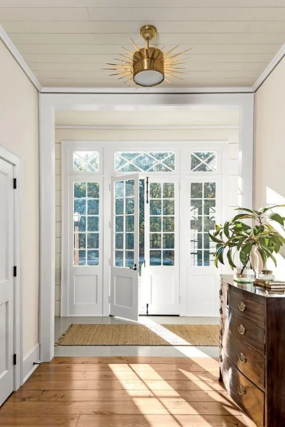 französische Fenstertüren weißer Rahmen Glasscheiben dängt viel natürliches Licht ins Innere des Hauses Flur sehr elegant gestaltet gut erhellt