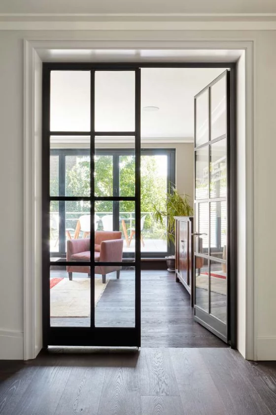 französische Fenstertüren zwei Flügel schwarzer Rahmen Übergang zum elegant gestalteten Wohnzimmer