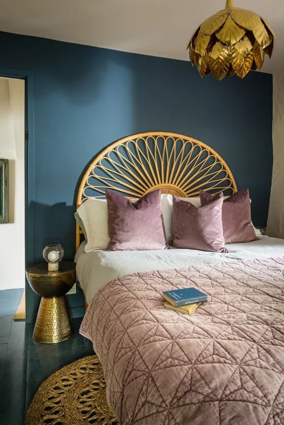 Goldene Akzente im Interieur Schlafzimmer Schlafkopfbett als halbe Sonne vor dunkler Wand