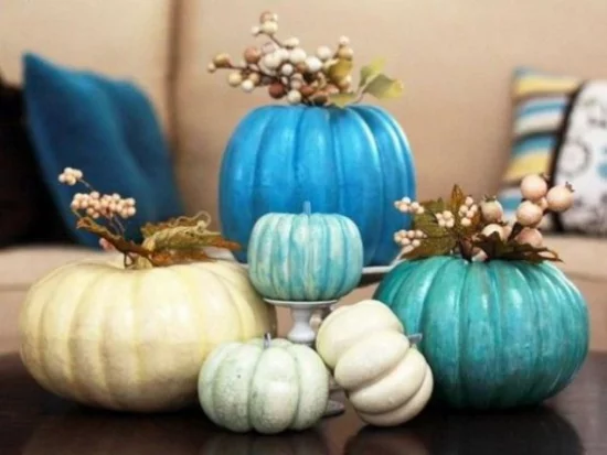 Herbstdeko auf dem Kaffeetisch Kürbisse in hellen Farben bemalen als Vasen verwenden