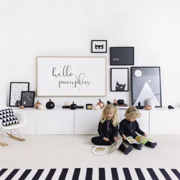 minimalistische Halloween Deko Kinderzimmer in schwarz-weiß schmücken zwei Kinder mit Büchern