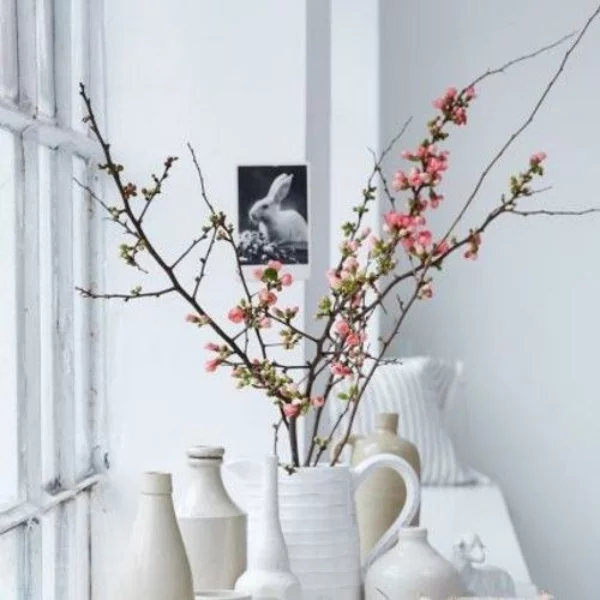 Blüten Zweige in weißen Vasen arrangiert neben dem Fenster