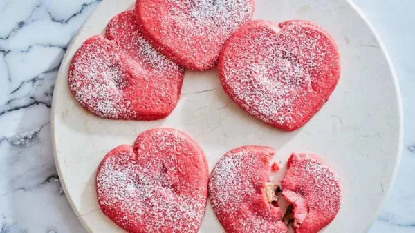 Herzhaftes zum Valentinstag in Herzform rote Herzen mit süßer Füllung mit Puderzucker bestreut