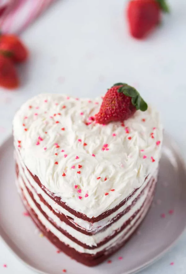 Herztorte zum Valentinstag mit weißer Sahnecreme mit frischer Erdbeere dekoriert