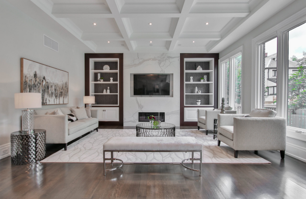 Typische Einrichtungsfehler vermeiden ein helles einladendes Ambiente schaffen Wohnzimmer in grauen Tönen Sofas Teppich eingebaute Wandschränke Gemälde hohe Fenster