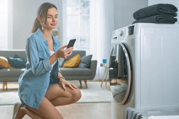 Stromfresser zu Hause moderne Waschmaschine stromsparendes Gerät Effizienzklasse A junge Frau