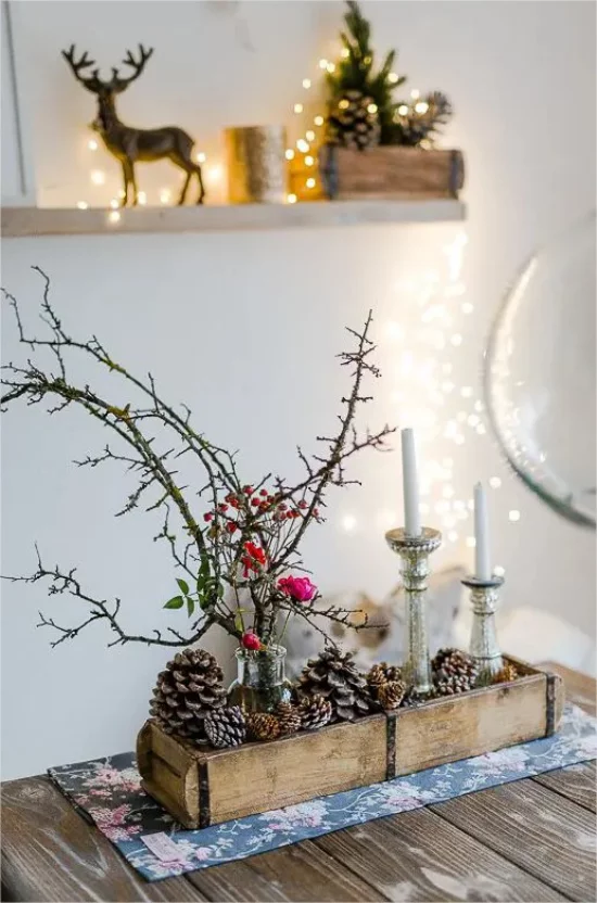 Rustikale Weihnachtsdeko drinnen Kisten Zweige Tannenzapfen Kerzen